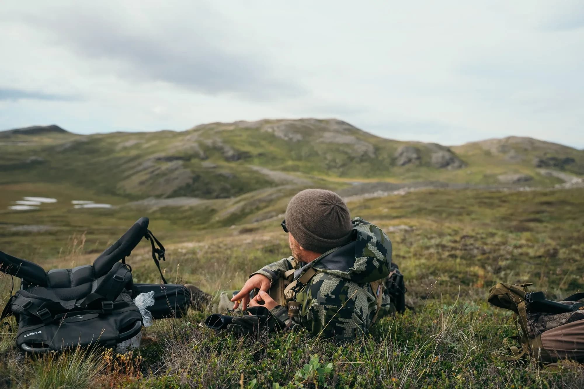 Hunter glassing from high ground over the tundra
