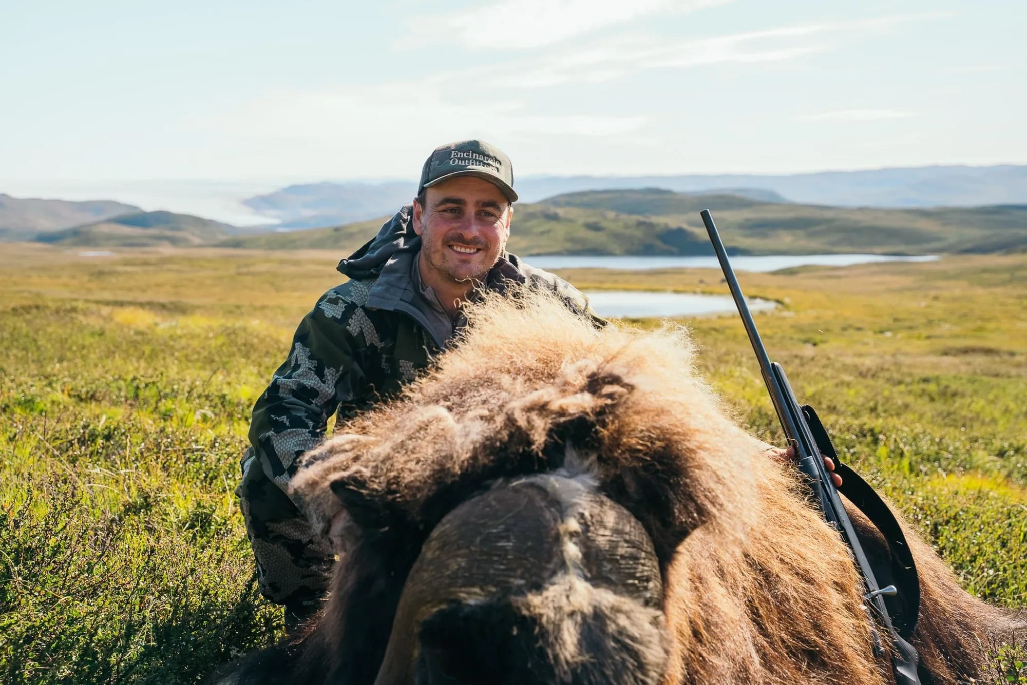 Hunter with a muskox bull taken by spot and stalk on the open tundra