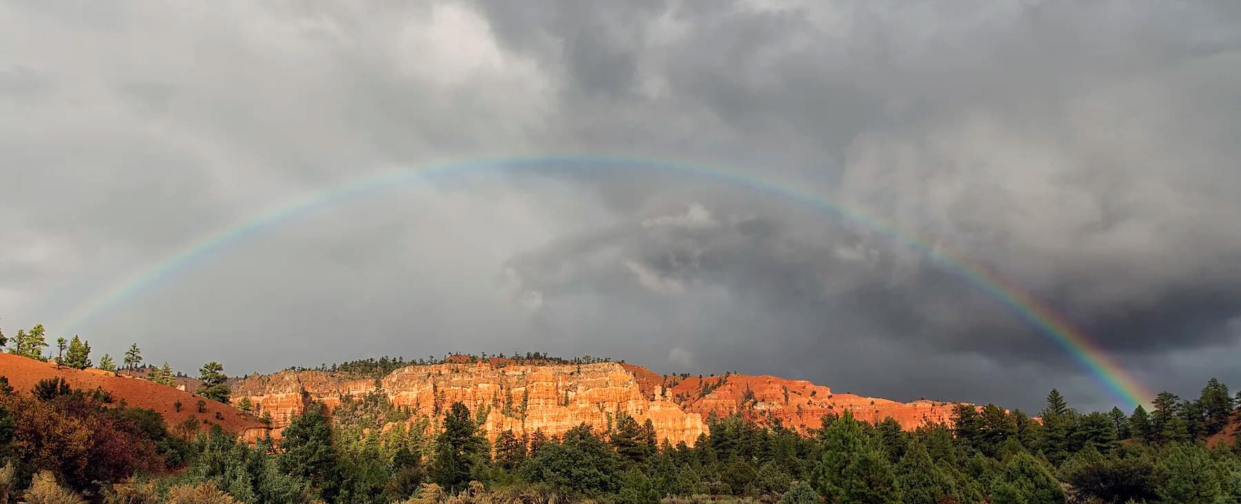 Red canyon rim under a breaking storm