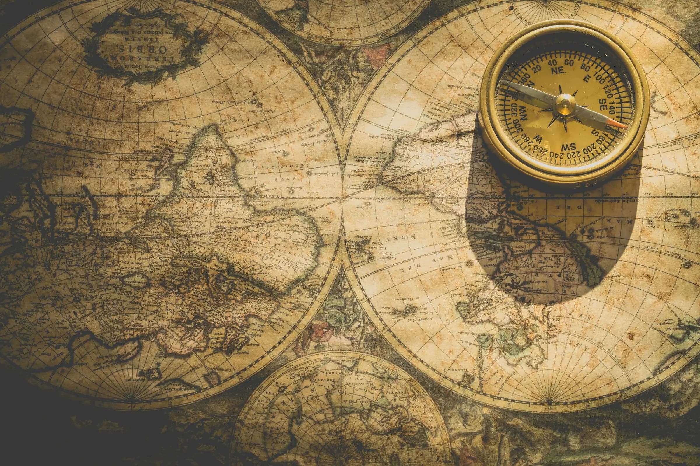 Analog compass on weathered map — the planning that earns Approved Ground