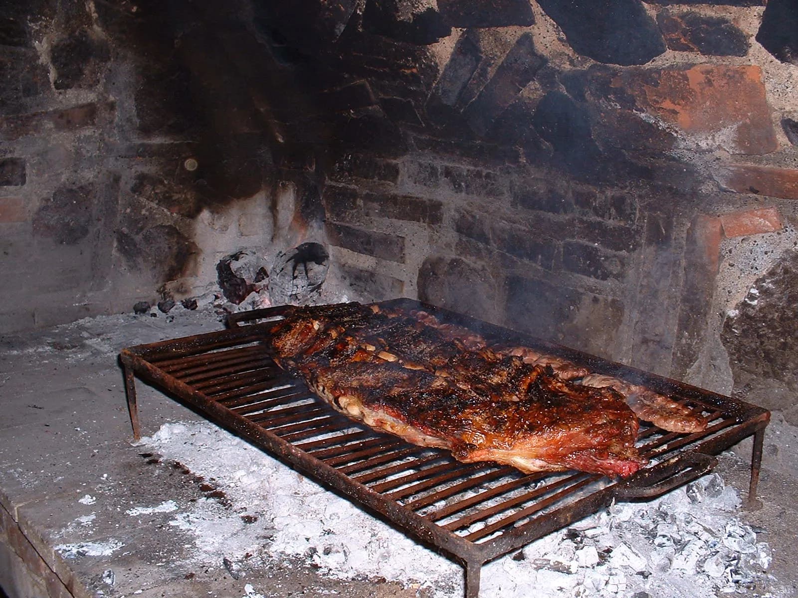 Asado over the coals at the end of a hunting day